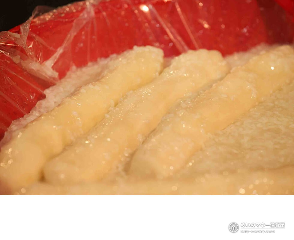 Close-up of several pale bettara-zuke radish pickles in clear bags