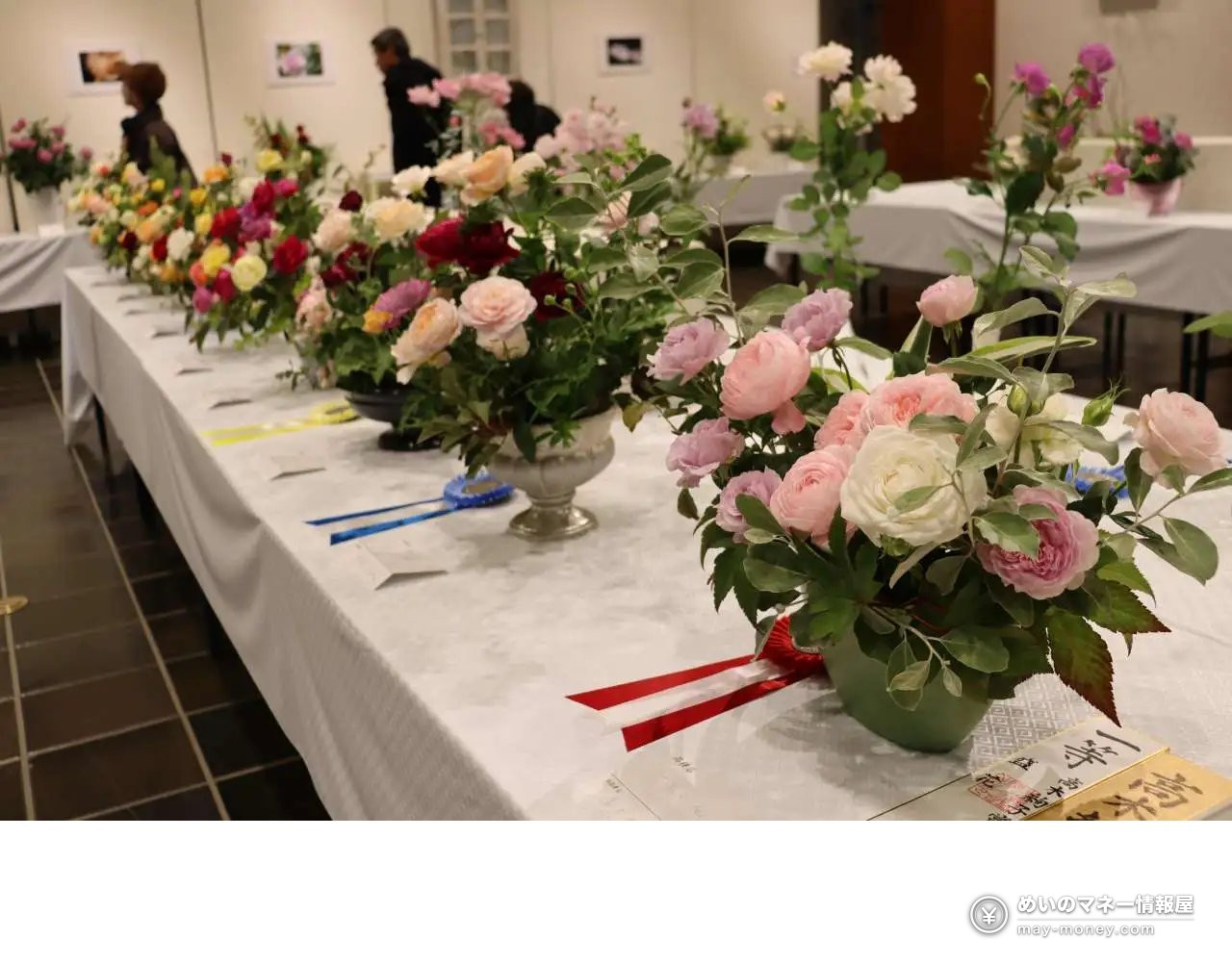 Rose arrangements tied with ribbons lined up on display tables
