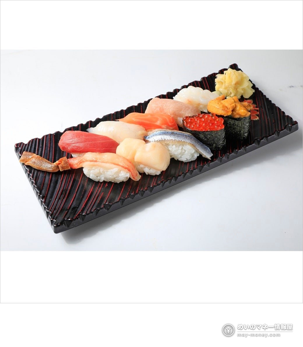Nigiri sushi with salmon roe and sea urchin gunkan on a black plate