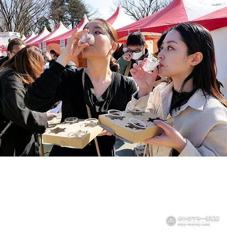 两位女性用小酒杯试饮日本酒
