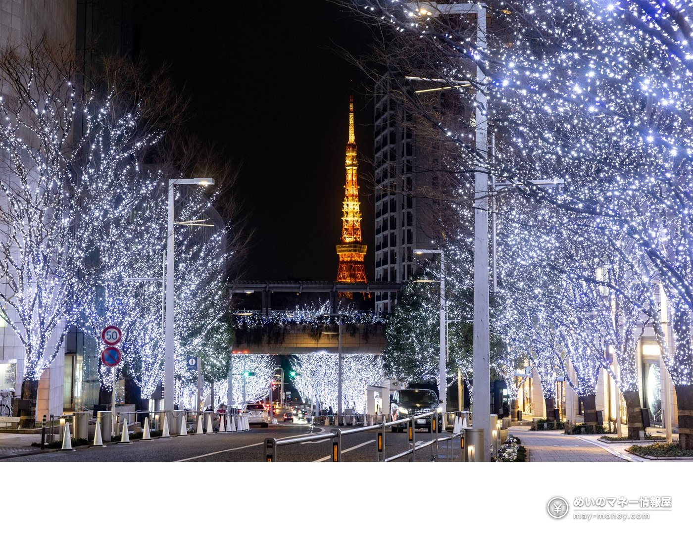 White illuminated trees on Keyakizaka avenue with Tokyo Tower glowing orange in the distance