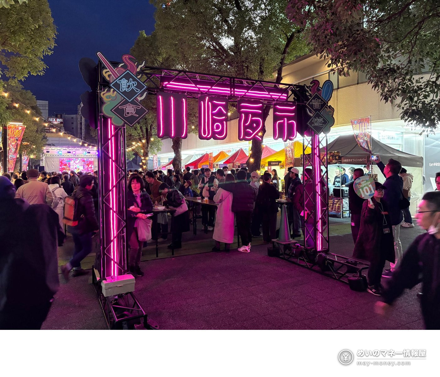 夜晚的川崎夜市会场入口，粉色霓虹招牌与人潮