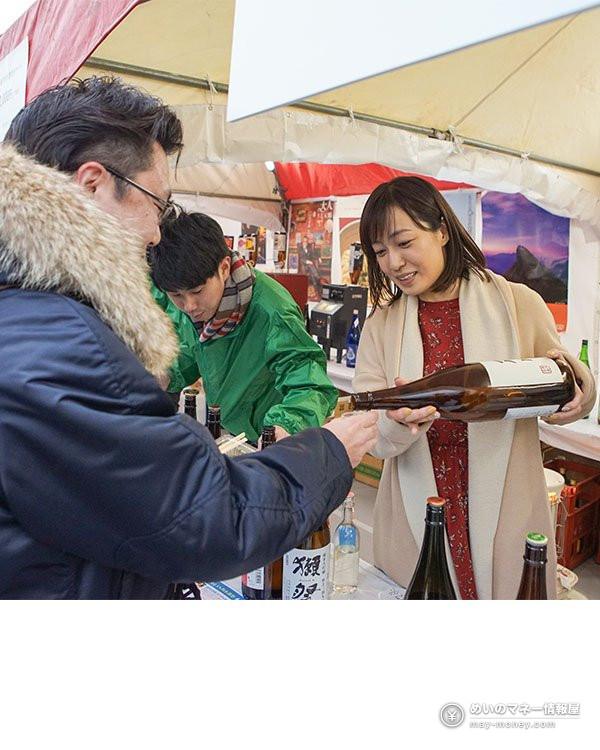 Sake Matsuri Japan Autumn in Okachimachi: Free Entry, 11 Breweries and 113 Sakes 4 A woman pouring sake from a large bottle for a customer inside a festival tent