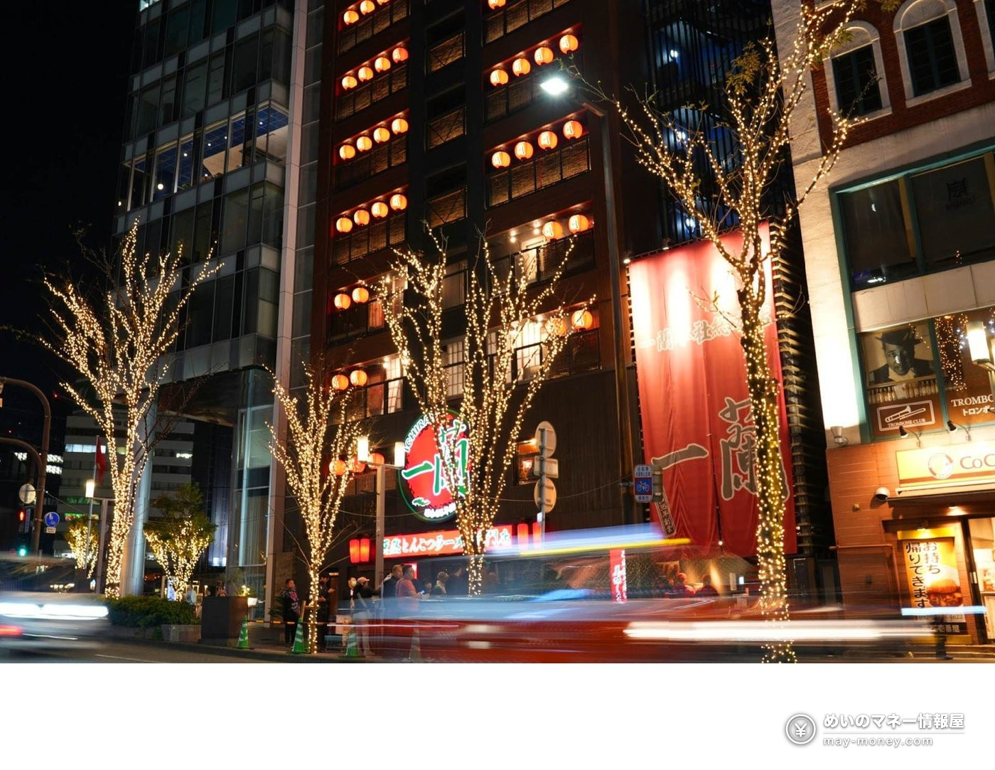一蘭の看板が見える夜の通りとイルミネーションをまとった街路樹