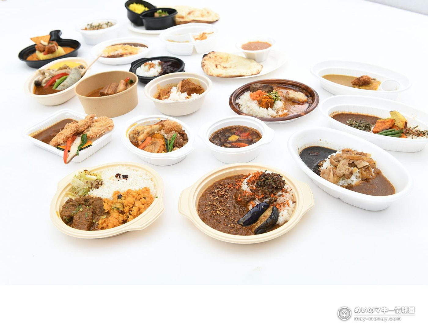容器に入ったさまざまなカレーとナンを並べた写真