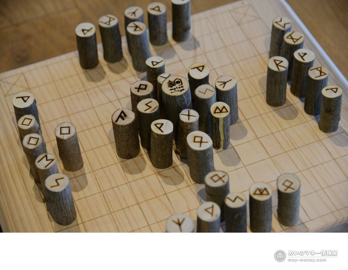 Wooden Hnefatafl pieces with burned-in runes on a gridded wooden board
