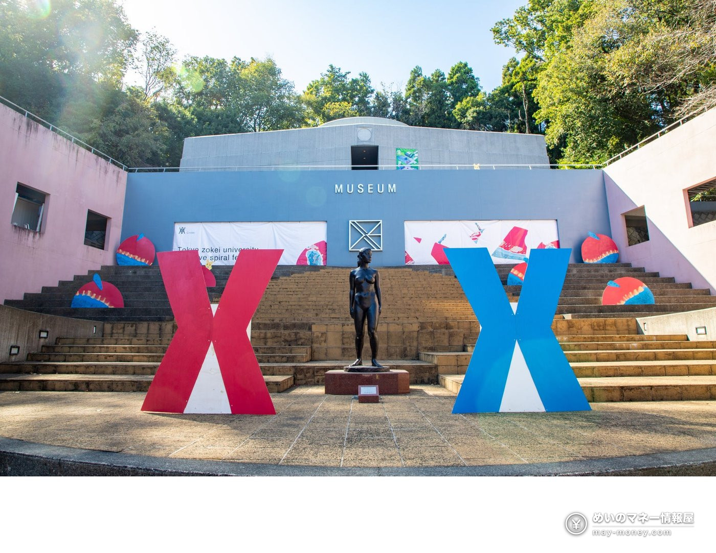 A statue on steps outside the museum with red and blue decorations at the 2025 festival