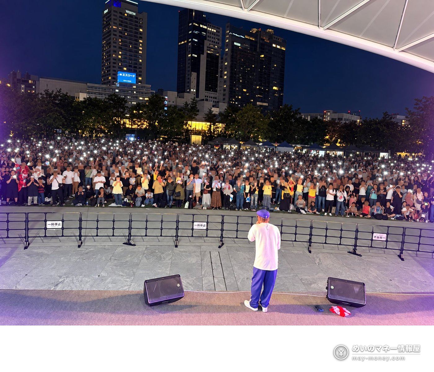過去の麦食音祭で夜の野外ステージを囲みスマートフォンのライトを掲げる観客