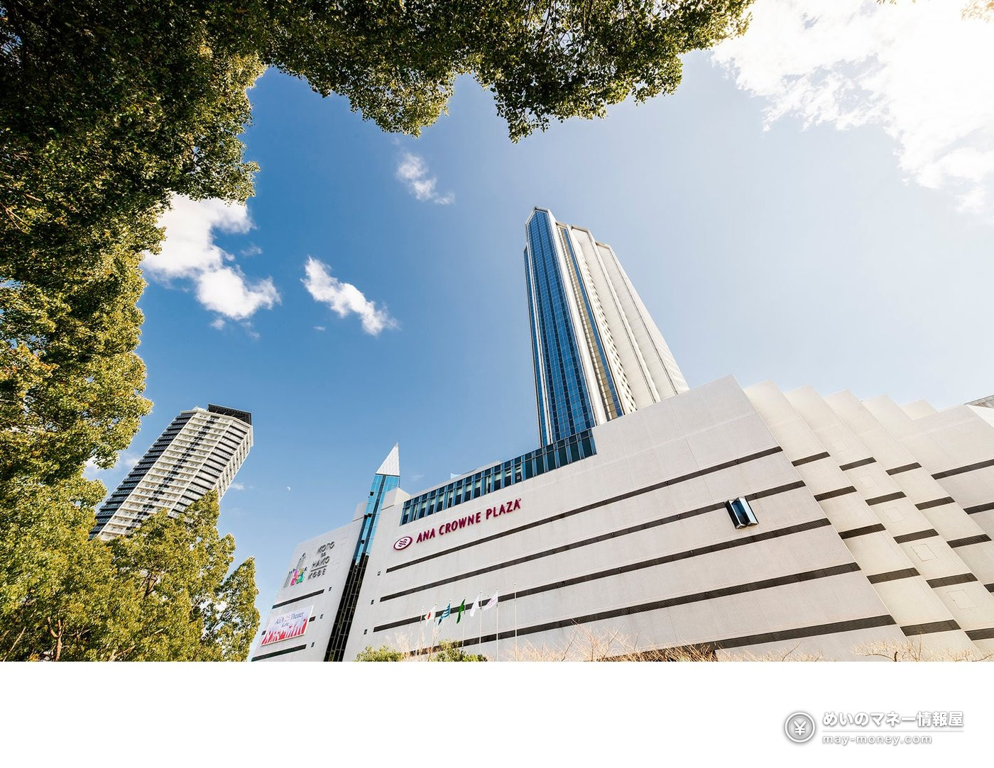 Exterior of ANA Crowne Plaza Kobe framed by trees beneath a blue sky