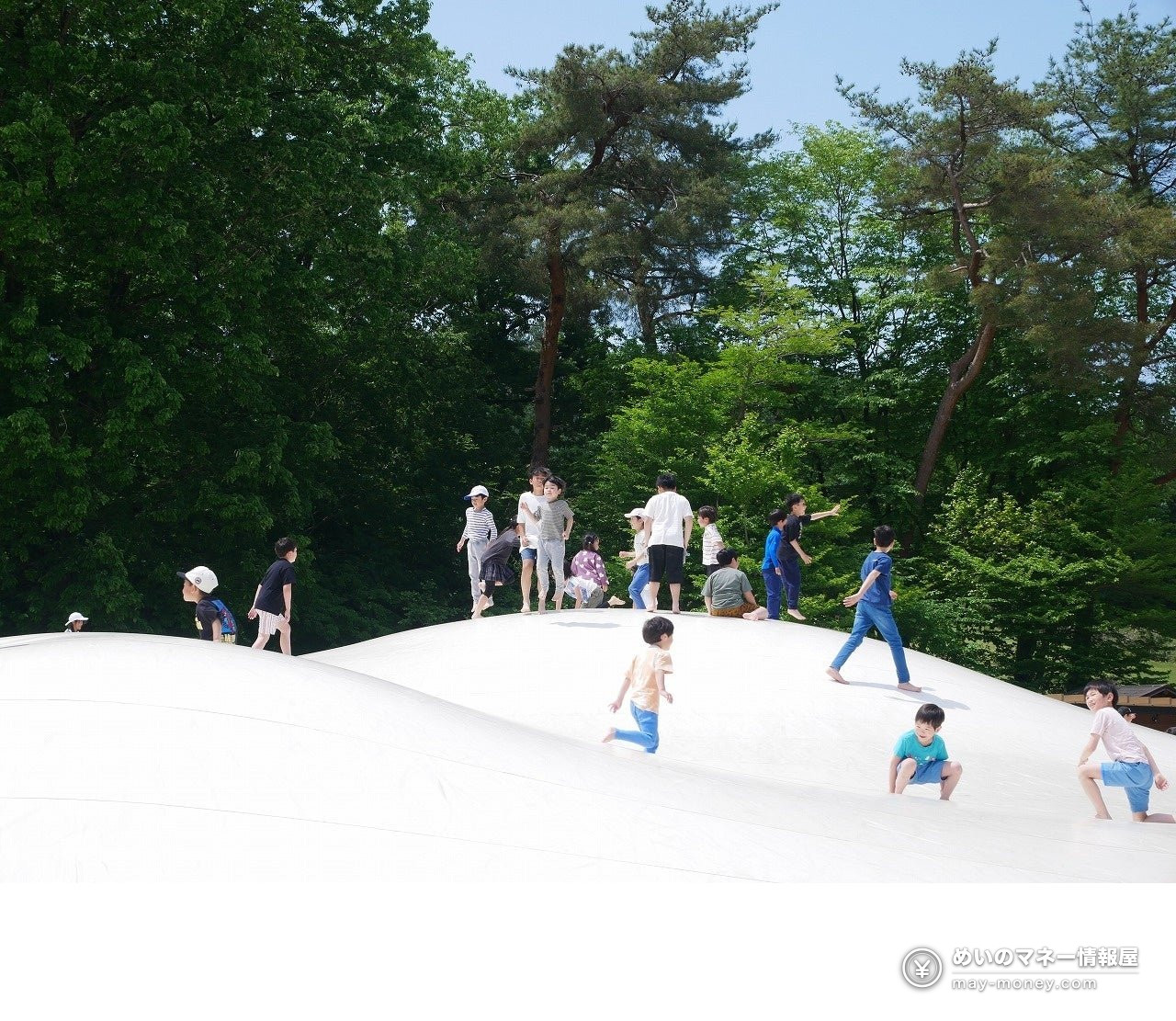 Children playing on a large white inflatable trampoline dome