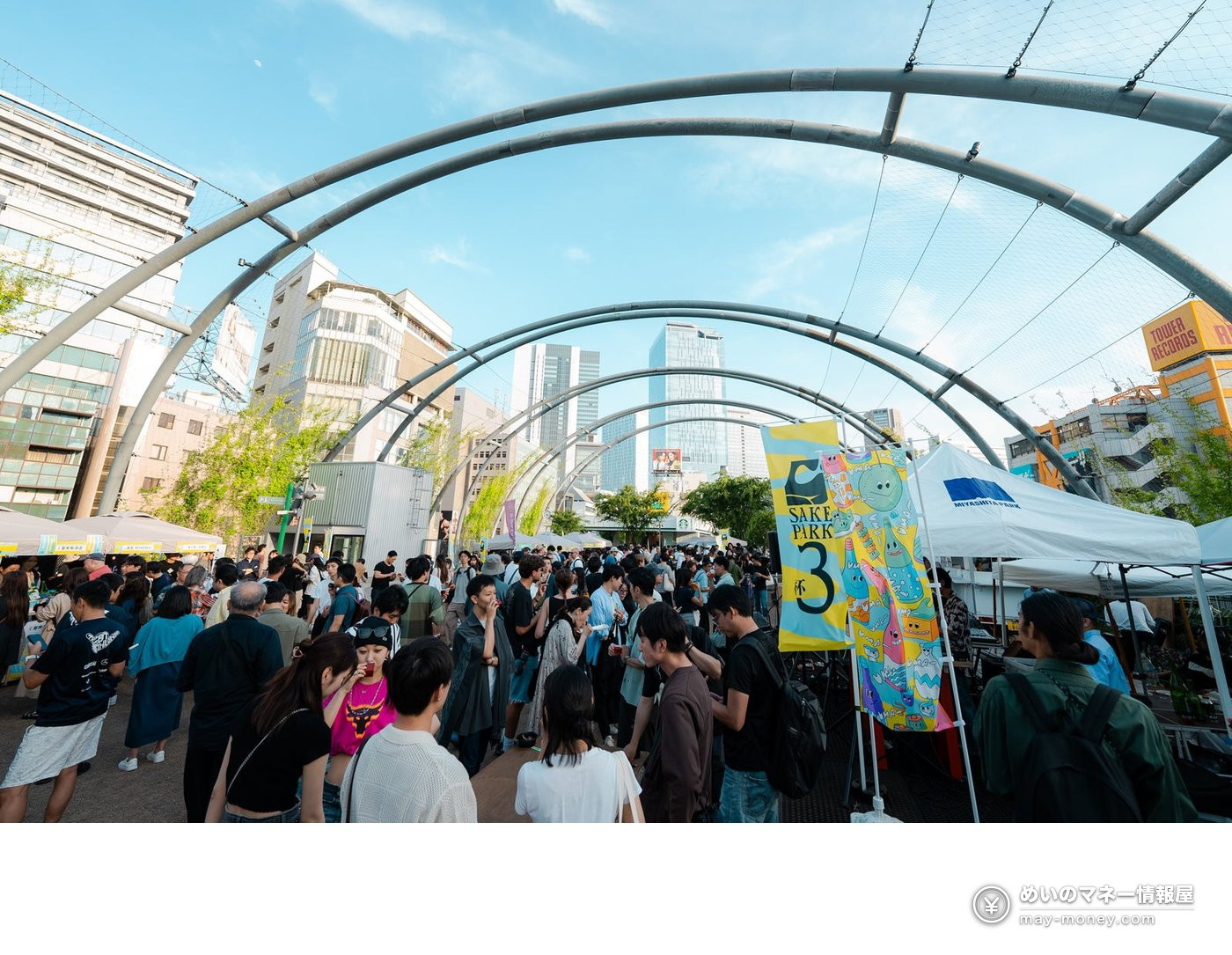 Crowds gathering under the arched roof at an earlier SAKE PARK, with a SAKE PARK 3 flag