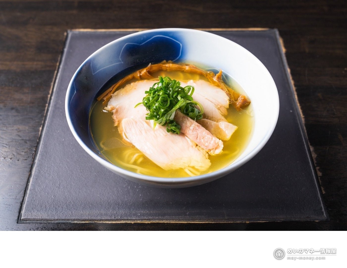 Shio-style ramen in a clear golden broth topped with chicken chashu and green onions