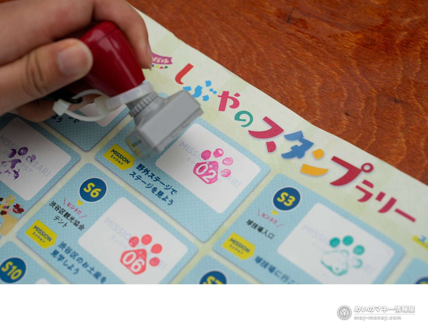 Furusato Shibuya Festival at Yoyogi Park: Free Entry, Akita Dogs, Ponies and 130 Tents (Nov 7–8) 5 A hand pressing a paw-print stamp onto a stamp rally card