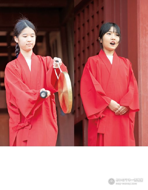 赤い衣装を着た少女2人。1人はどらを手にしている