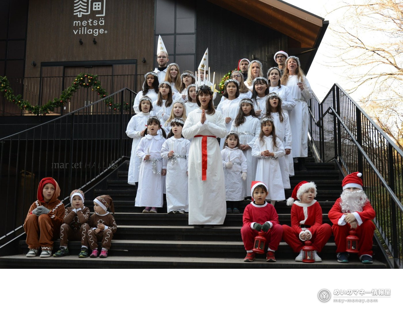 Children in white Lucia robes and Christmas costumes lined up on steps