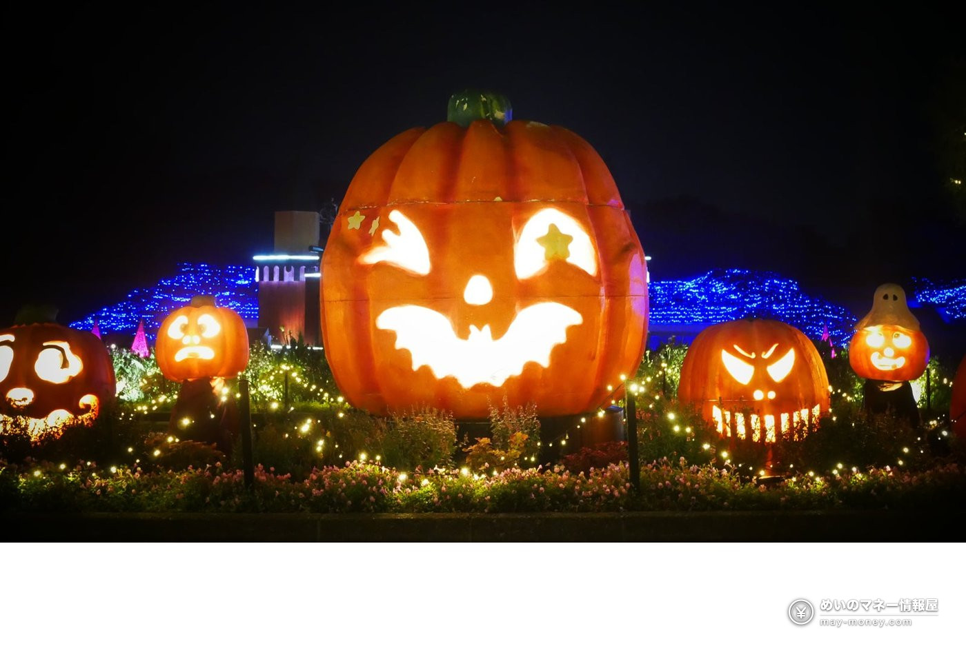 A giant jack-o-lantern pumpkin sculpture lit up at night