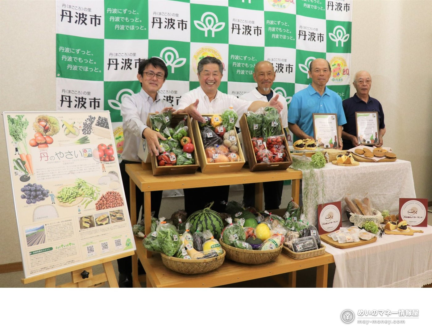 丹波市と丹のやさいの文字が入った背景幕の前で、野菜や菓子を並べて立つ5人の男性