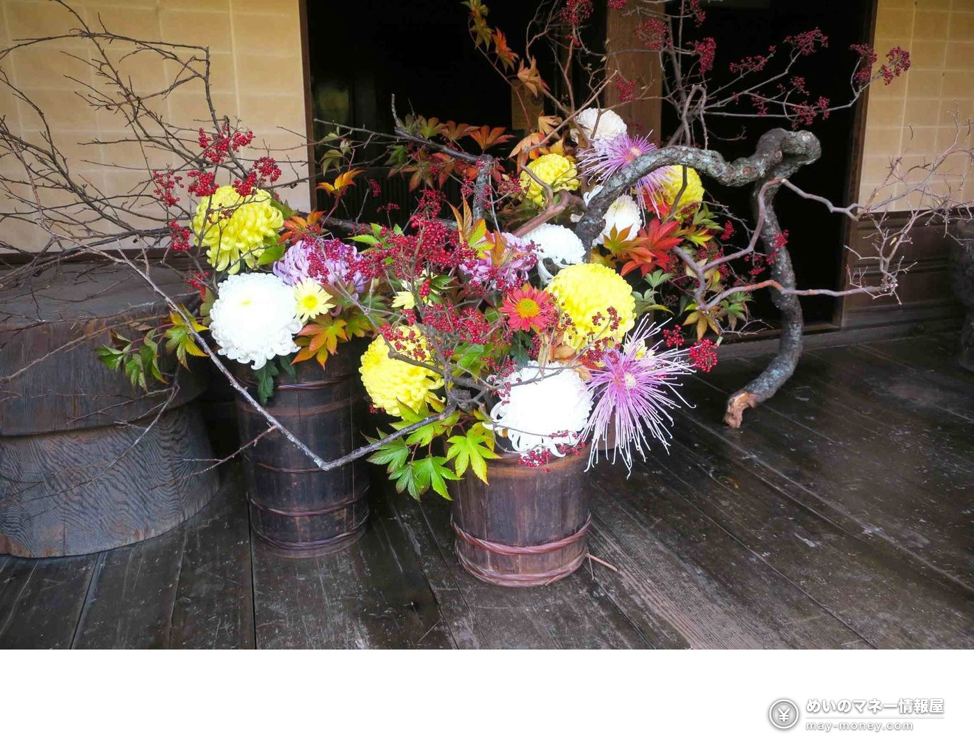 Chrysanthemums arranged in a wooden tub with red berries and autumn leaves