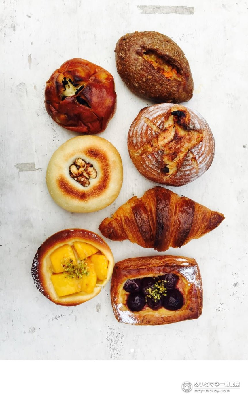 Seven kinds of bread including croissants and sweet buns on a white table