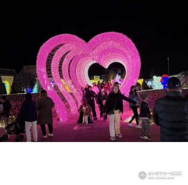 Pink heart-shaped light arches of the Love Tunnel with visitors walking through