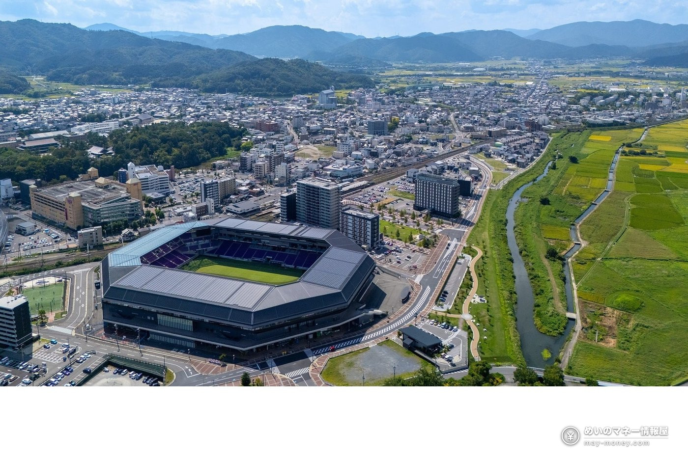 スタジアムや市街地、川、田畑、山々が広がる亀岡市の空撮写真