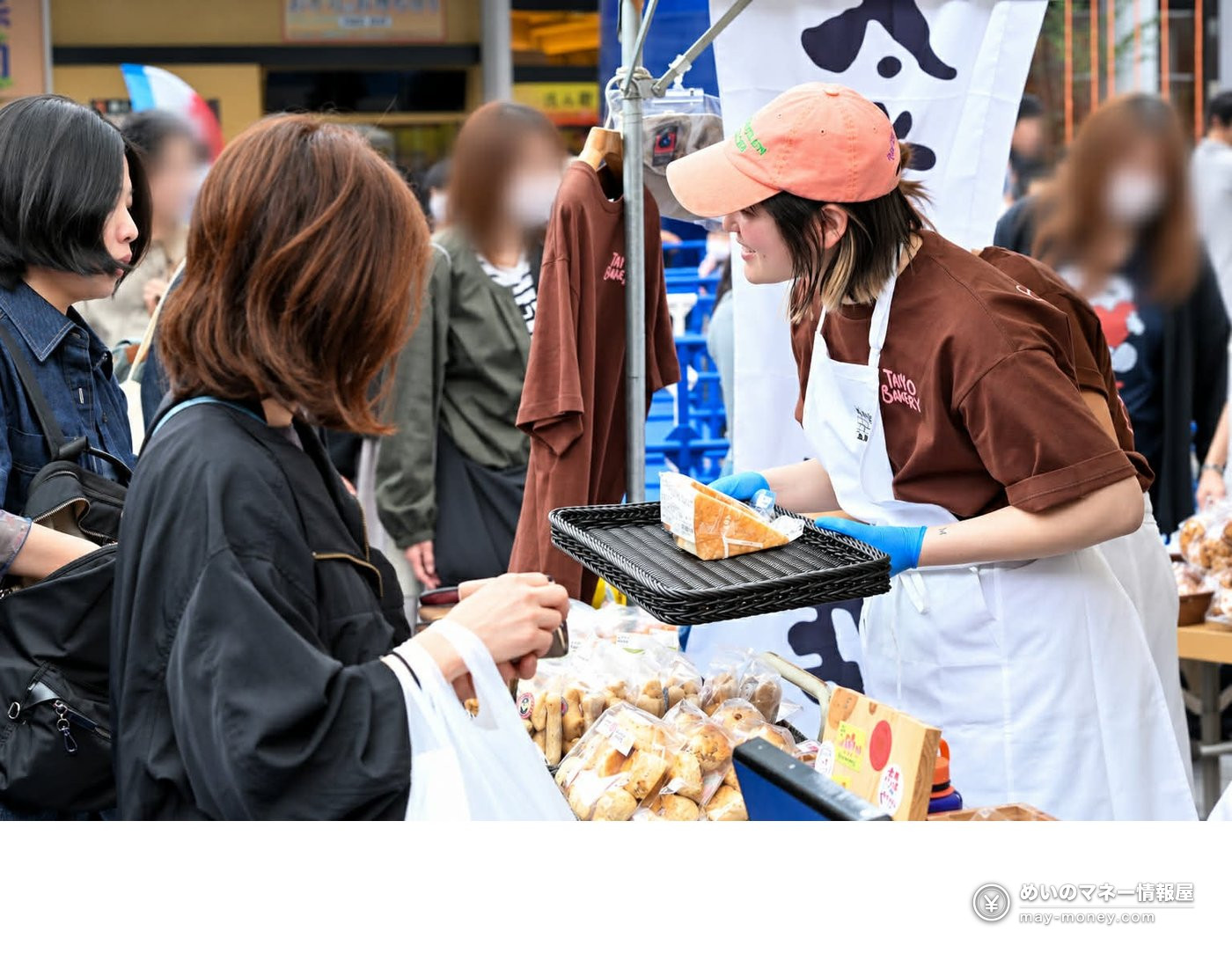 TAIYO BAKERYの販売スタッフが来場者にパンを渡す様子