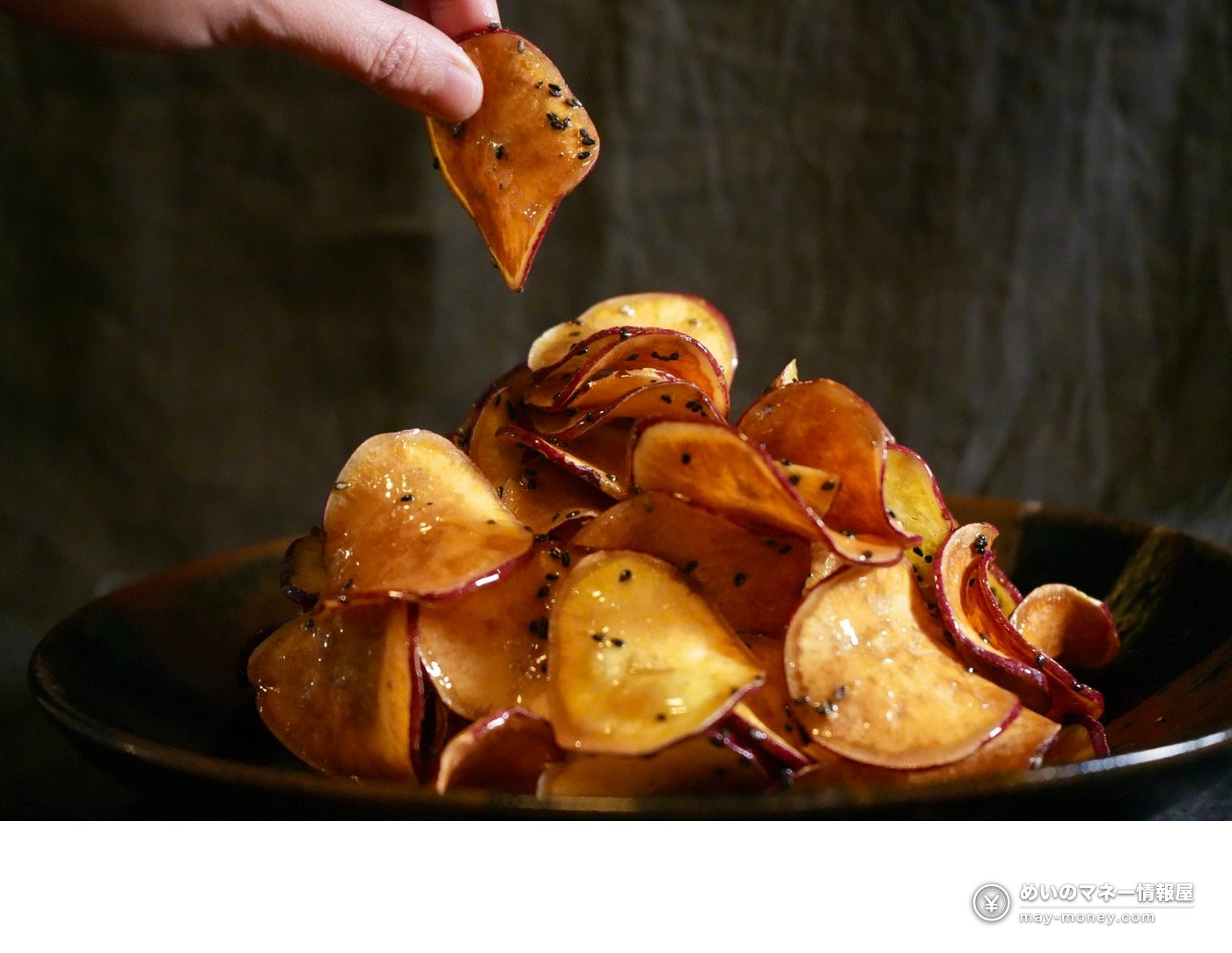 Yakiimo Hiroba at Azabudai Hills: Sweet Potatoes by a Bonfire 8 A plate of honey-glazed sweet potato chips with black sesame, one being picked up by hand
