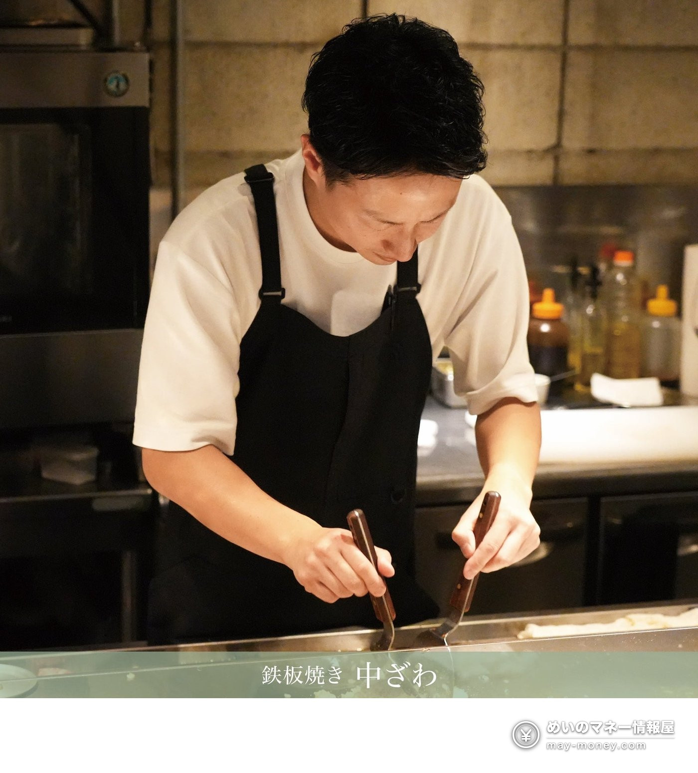 鉄板焼き 中ざわで鉄板に向かいヘラで調理する料理人