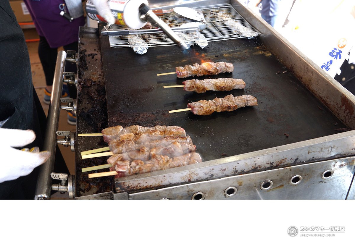 鉄板の上で焼かれる肉の串焼き