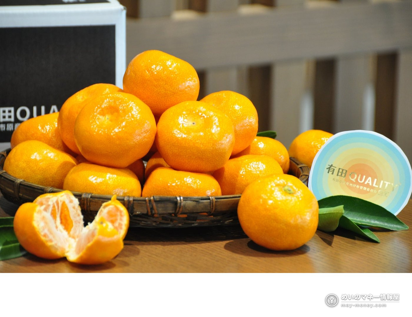 A basket of mikan with peeled fruit and the Arida QUALITY logo