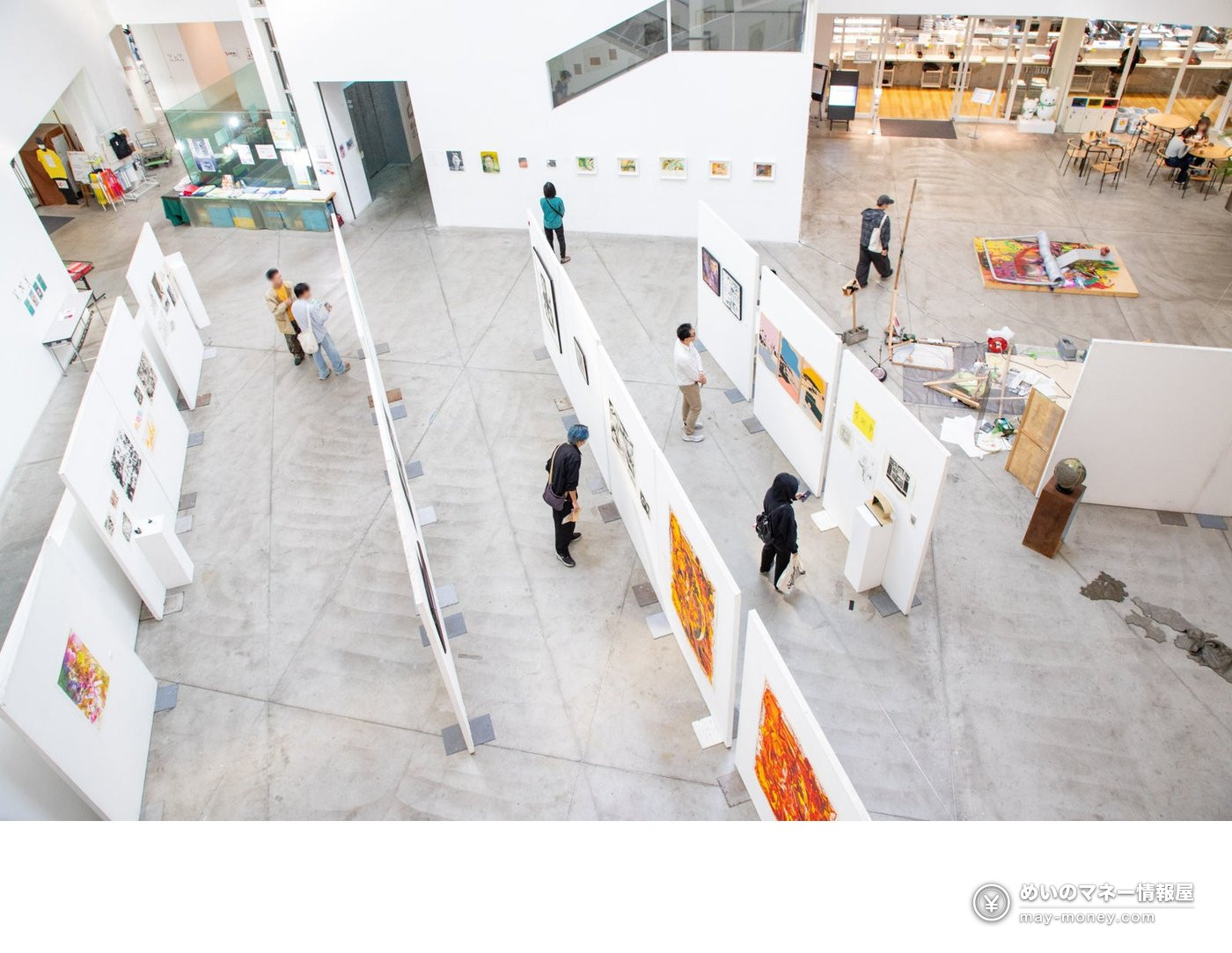Paintings, three-dimensional artworks and visitors in an exhibition space at the 2025 festival