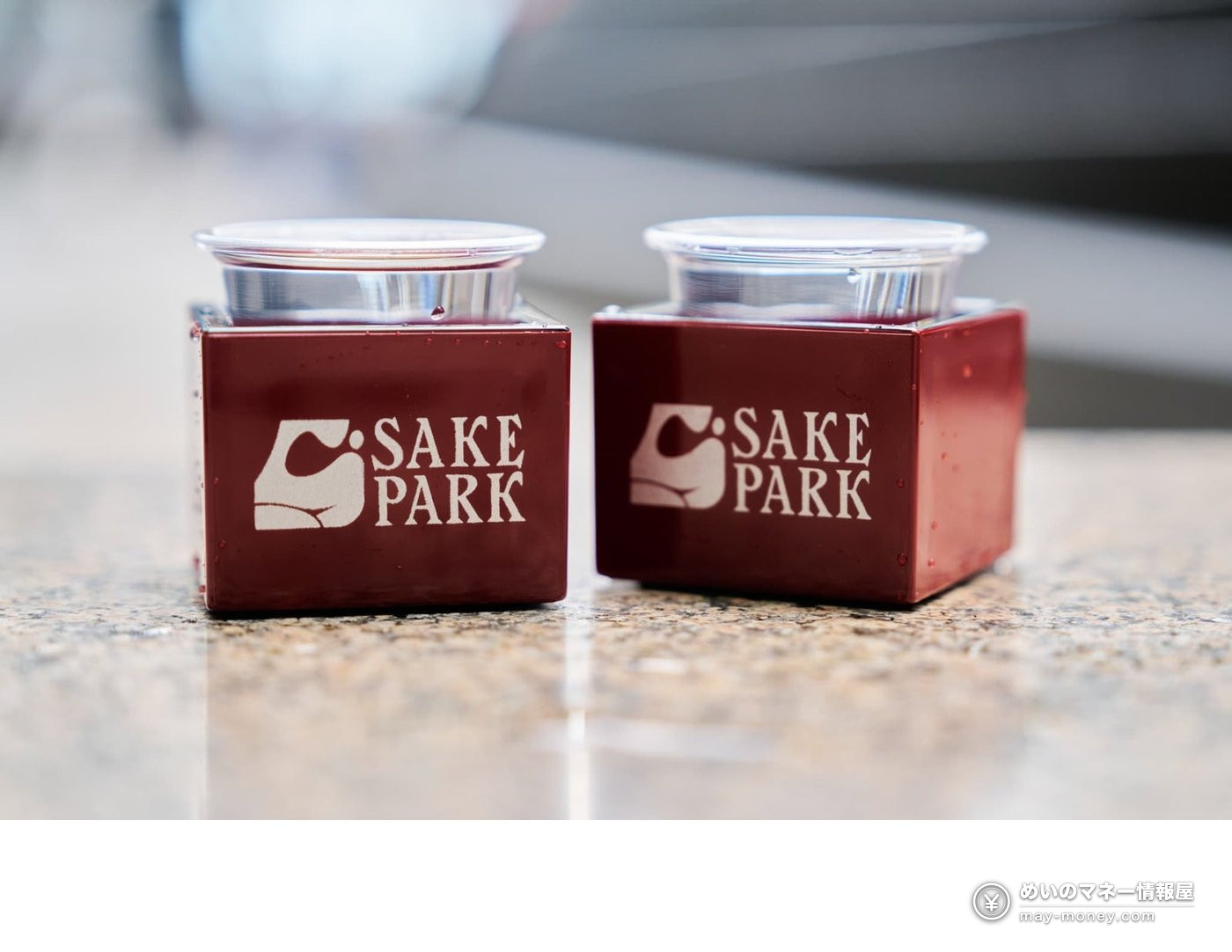 Two red square masu cups with the SAKE PARK logo