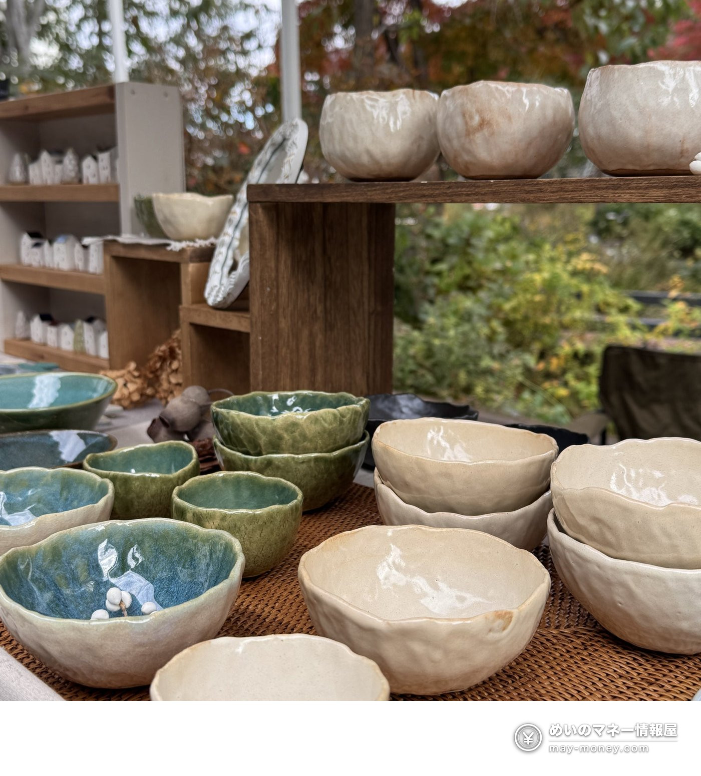 素朴な形や風合いの鉢を並べた屋外の陶器の展示台