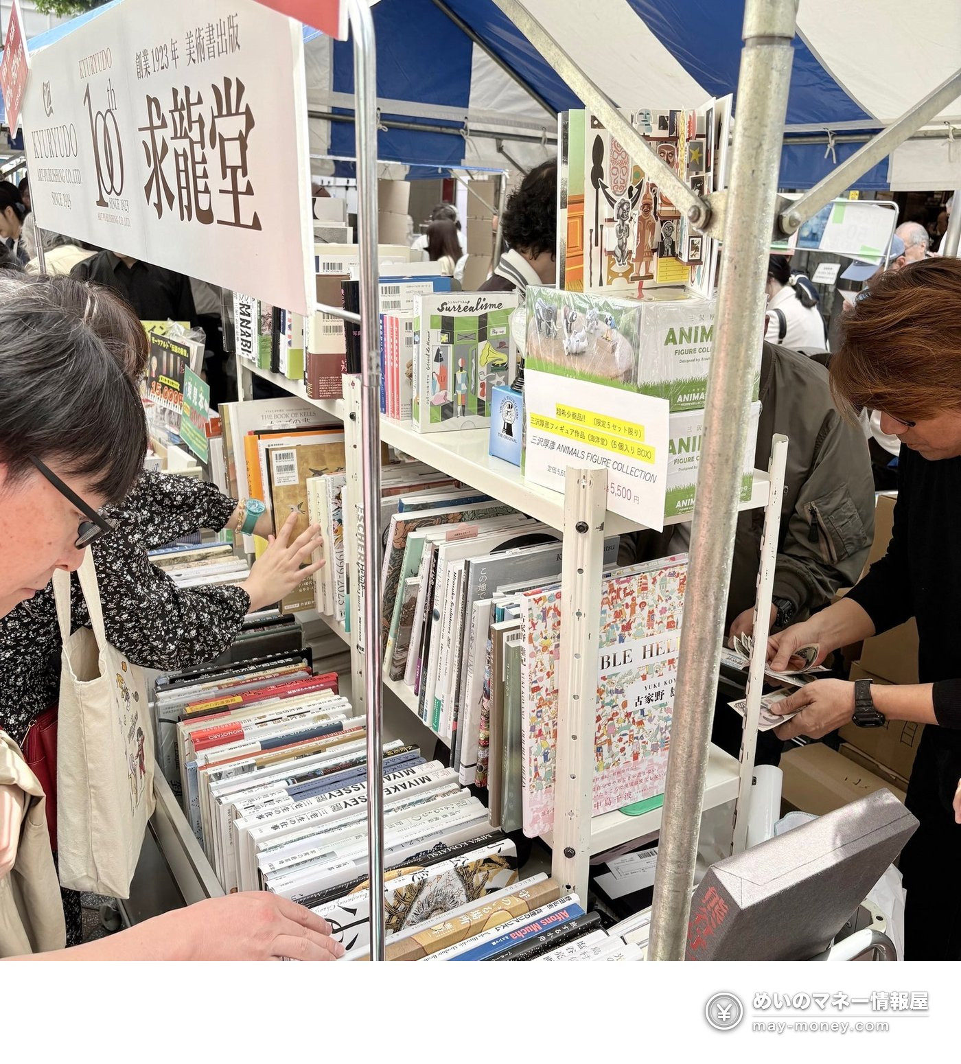 神保町「本の得々市」求龙堂出摊|美术书汚損本最高5折・森山大道海报限量(10/24・25) 4 帐篷下的书架前客人正在挑书,旁边店员在结账,架上还有手办