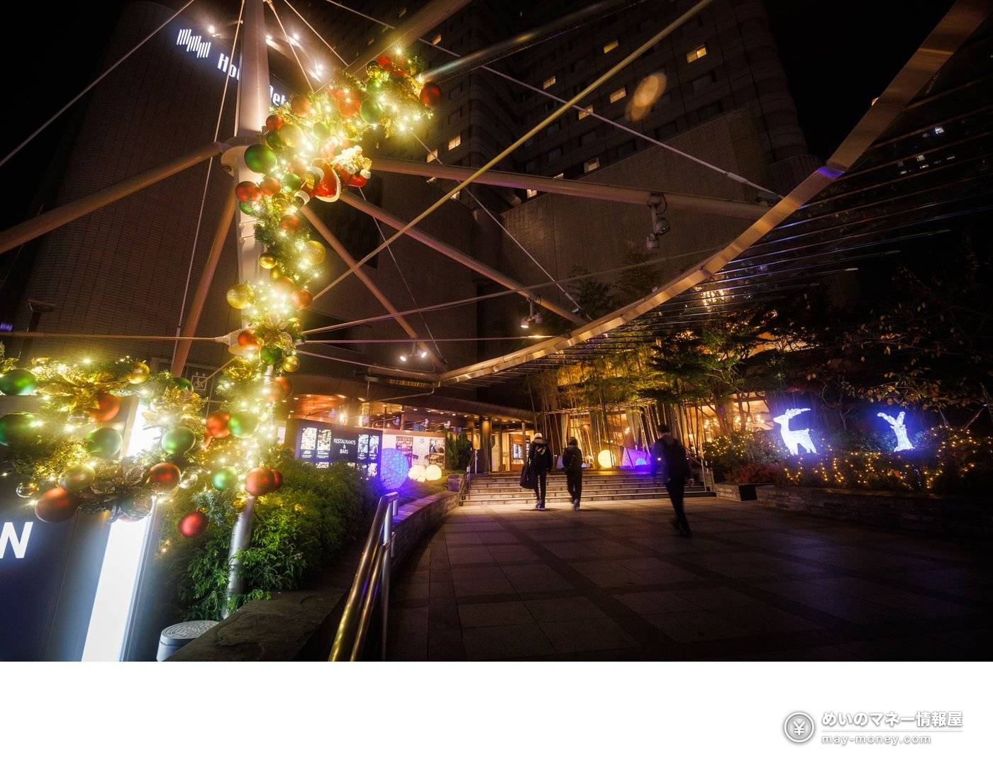 Hotel entrance at night with Christmas decorations and glowing reindeer figures