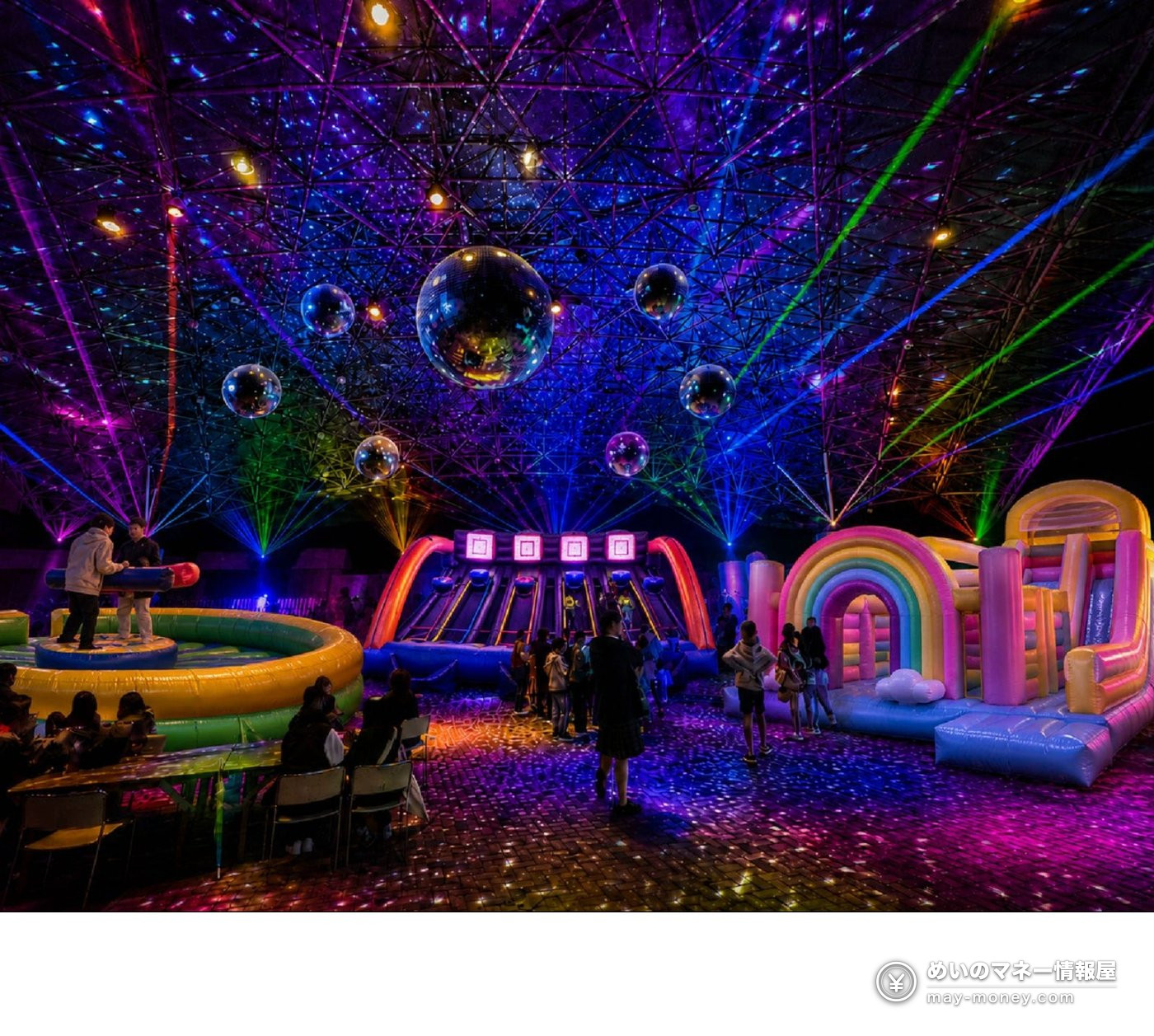 Indoor area with inflatable play equipment under a mirror ball and laser lights