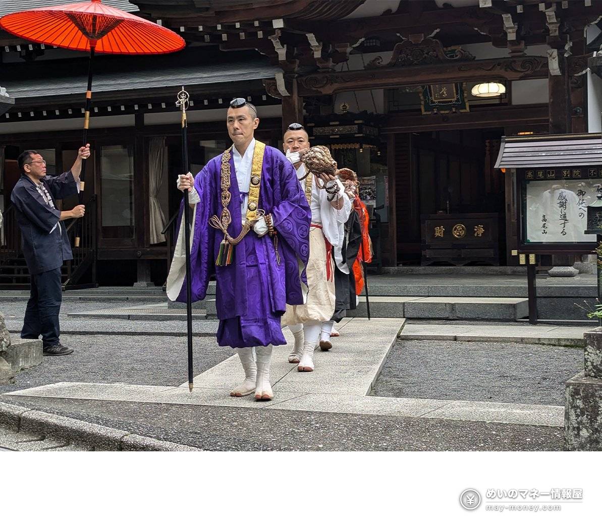 手持伞和锡杖的山伏们列队走过寺院境内