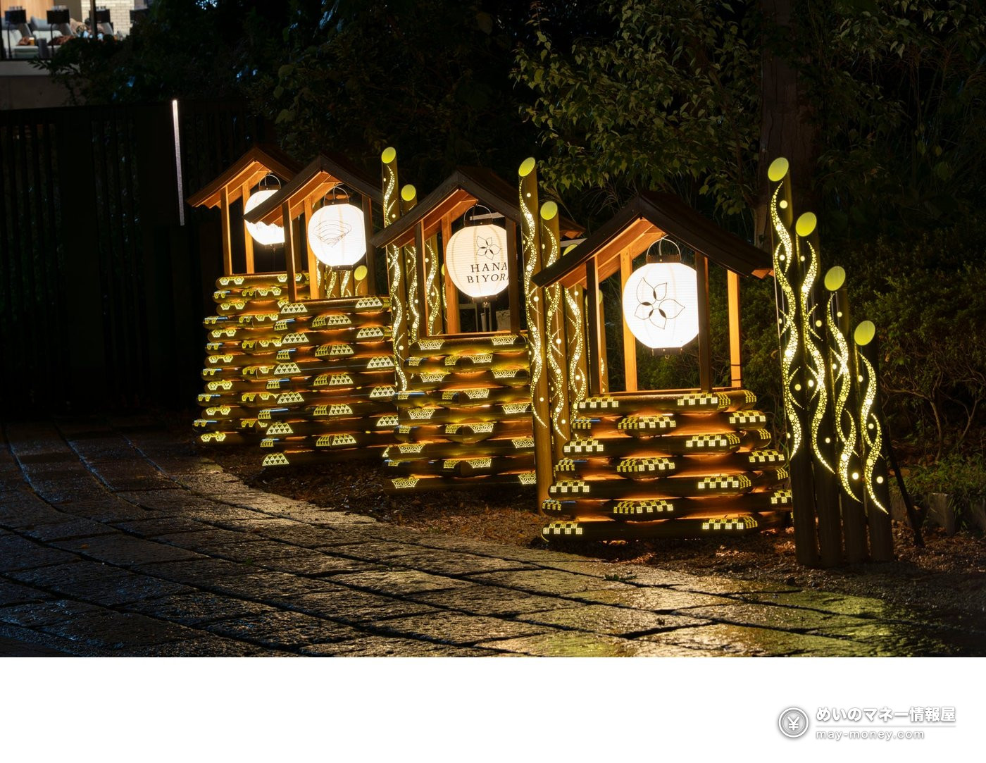 A bamboo frame topped with a roofed lantern and a paper lantern printed with HANA BIYORI