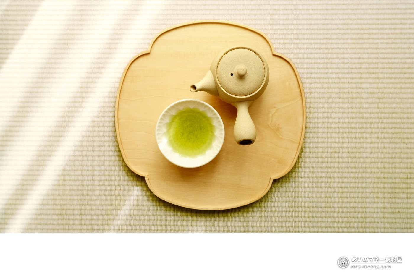 木製の盆に置かれた急須と緑茶入りの白い茶碗
