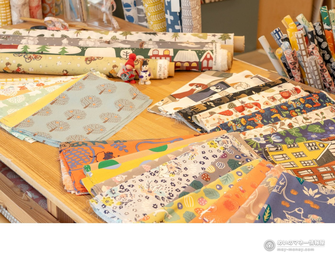 Colorful Nordic-style fabrics with animal, house and flower patterns spread on a table