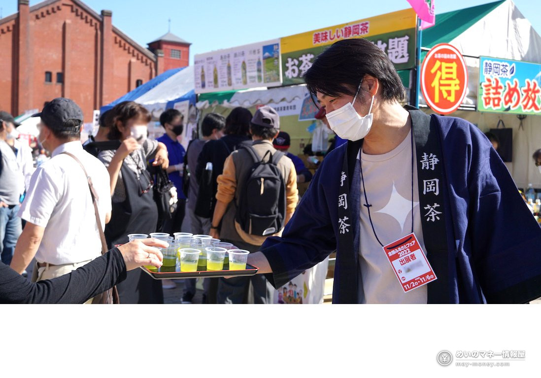 法被姿の男性がトレーにのせた静岡茶の試飲を配っている様子