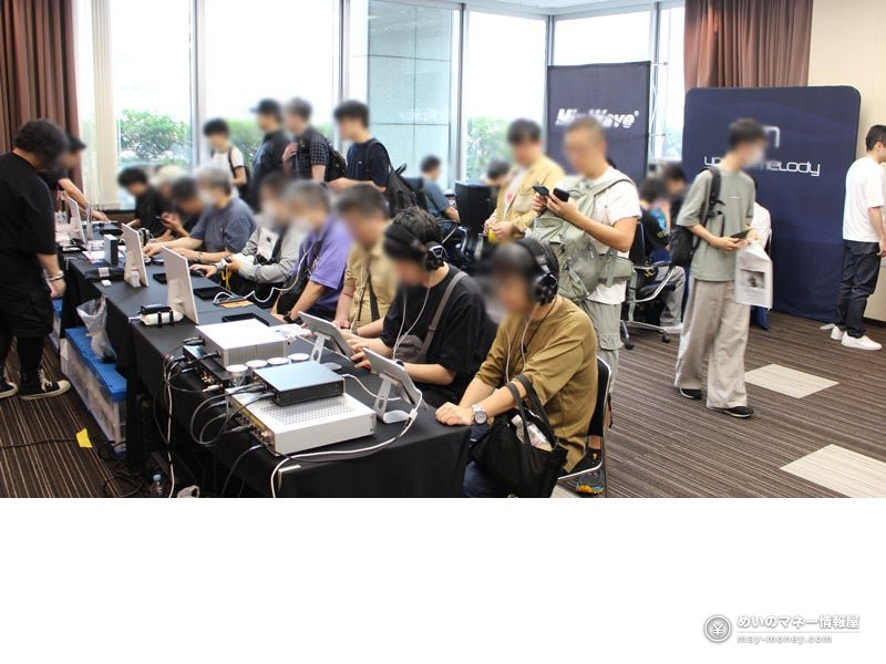長机に並んだヘッドホンアンプを、来場者がヘッドホンを着けて聴き比べている様子