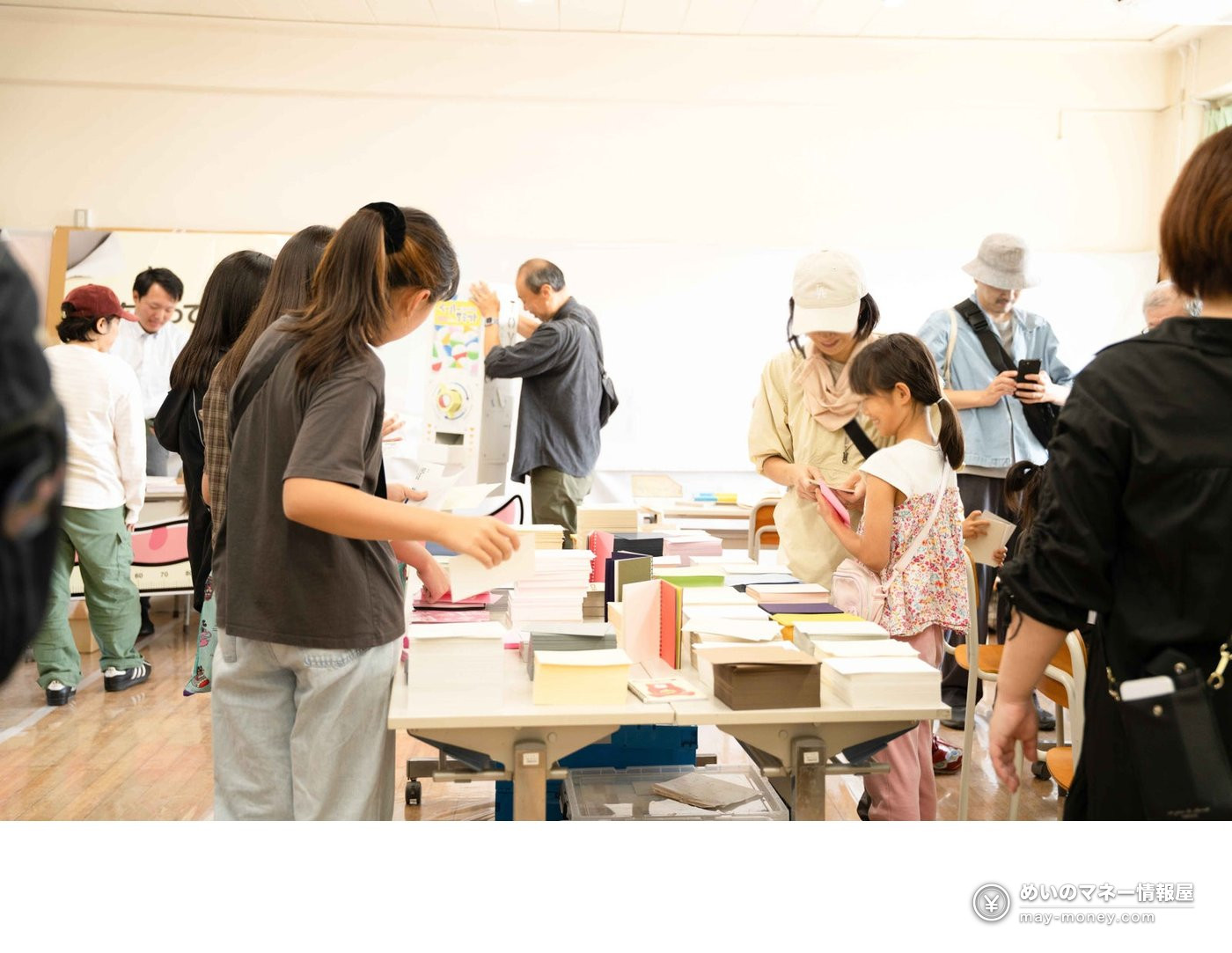 Children and adults choosing colourful paper piled on a table